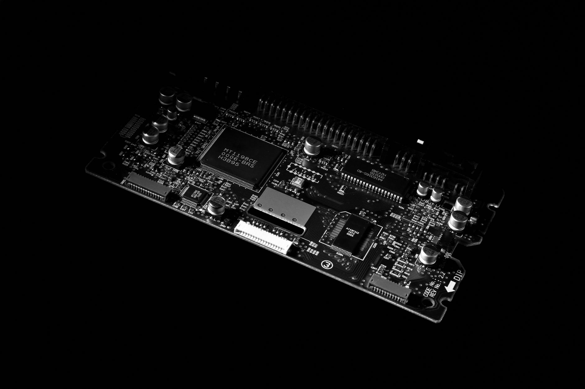 Image détaillée en noir et blanc d'une carte de circuit imprimé d'ordinateur, présentant des composants technologiques.