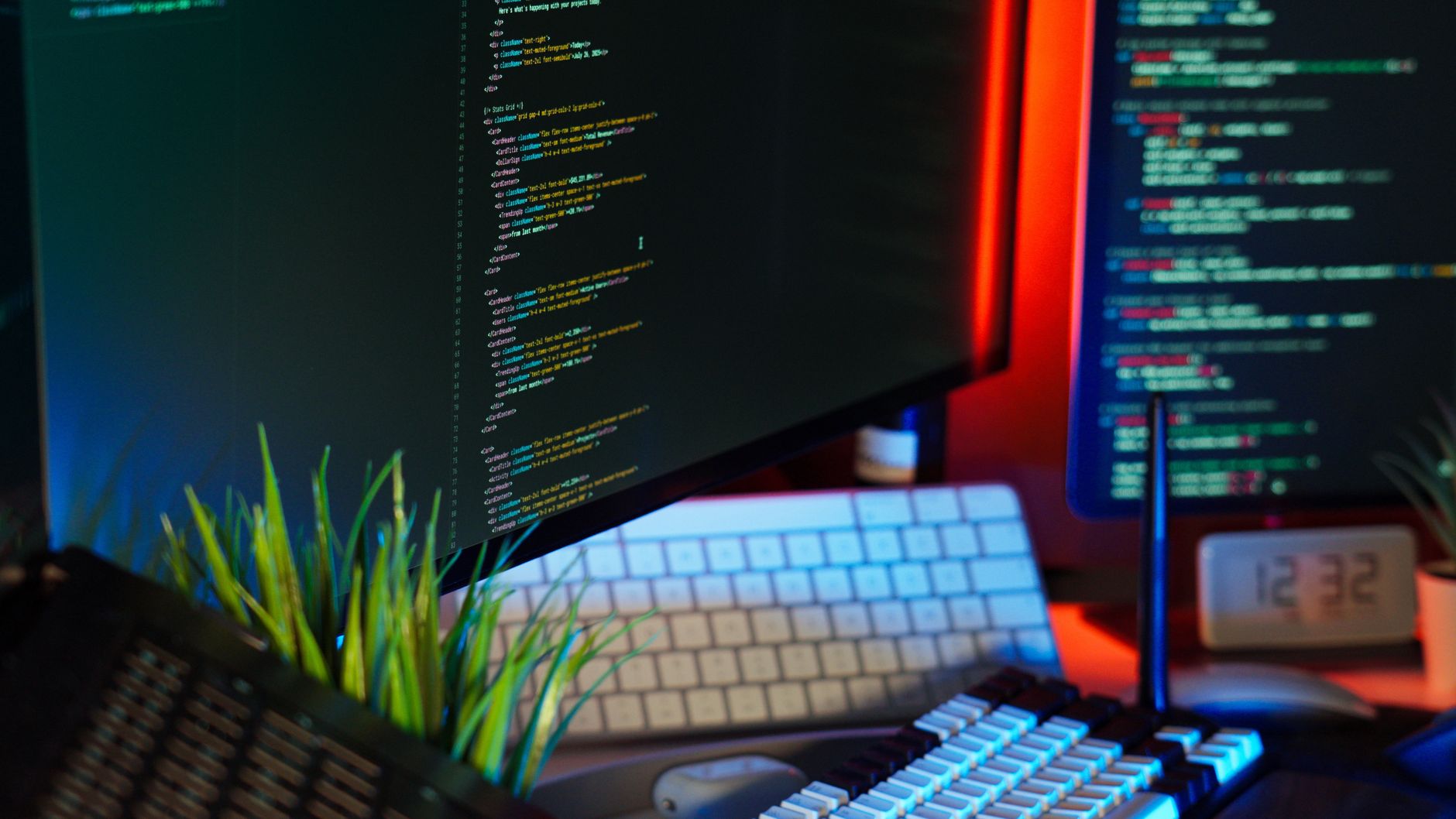 Un espace de travail animé montrant des écrans d'ordinateur avec du code, un clavier et des accessoires technologiques.